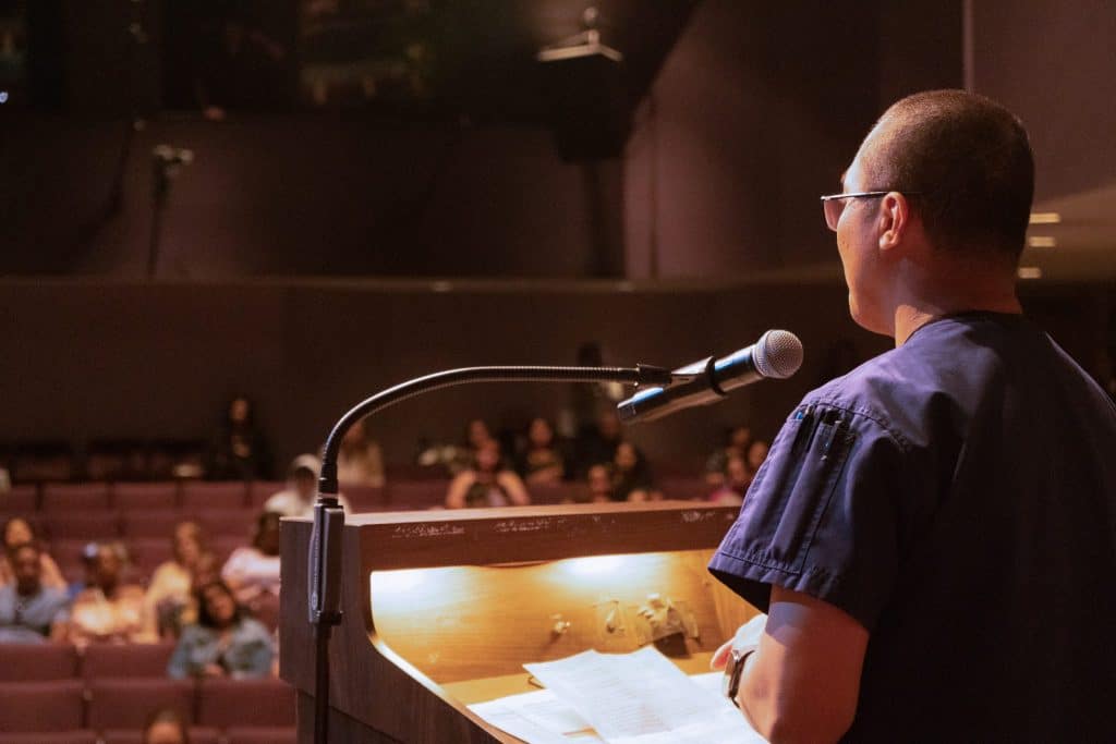 VVC alumnus Michael Baisa speaks from the podium to scholarship recipients seated in the theater