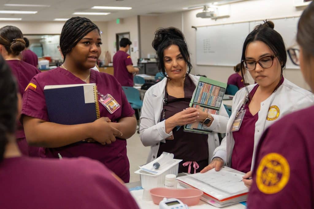 A Victor Valley College health sciences instructor guiding students through a clinical skills exercise in the lab