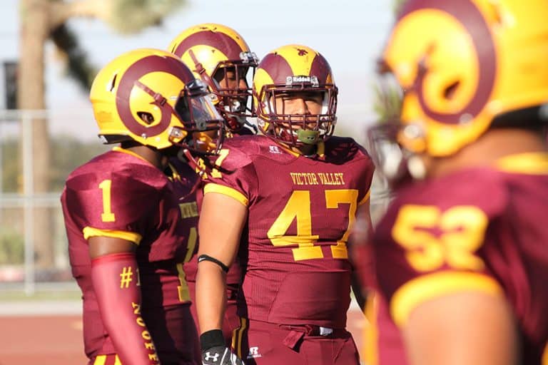 Victor Valley College Rams football players in maroon and gold uniforms on the field