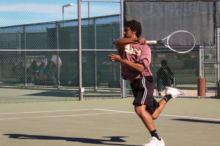 A Victor Valley College Rams tennis player hitting a forehand on the court