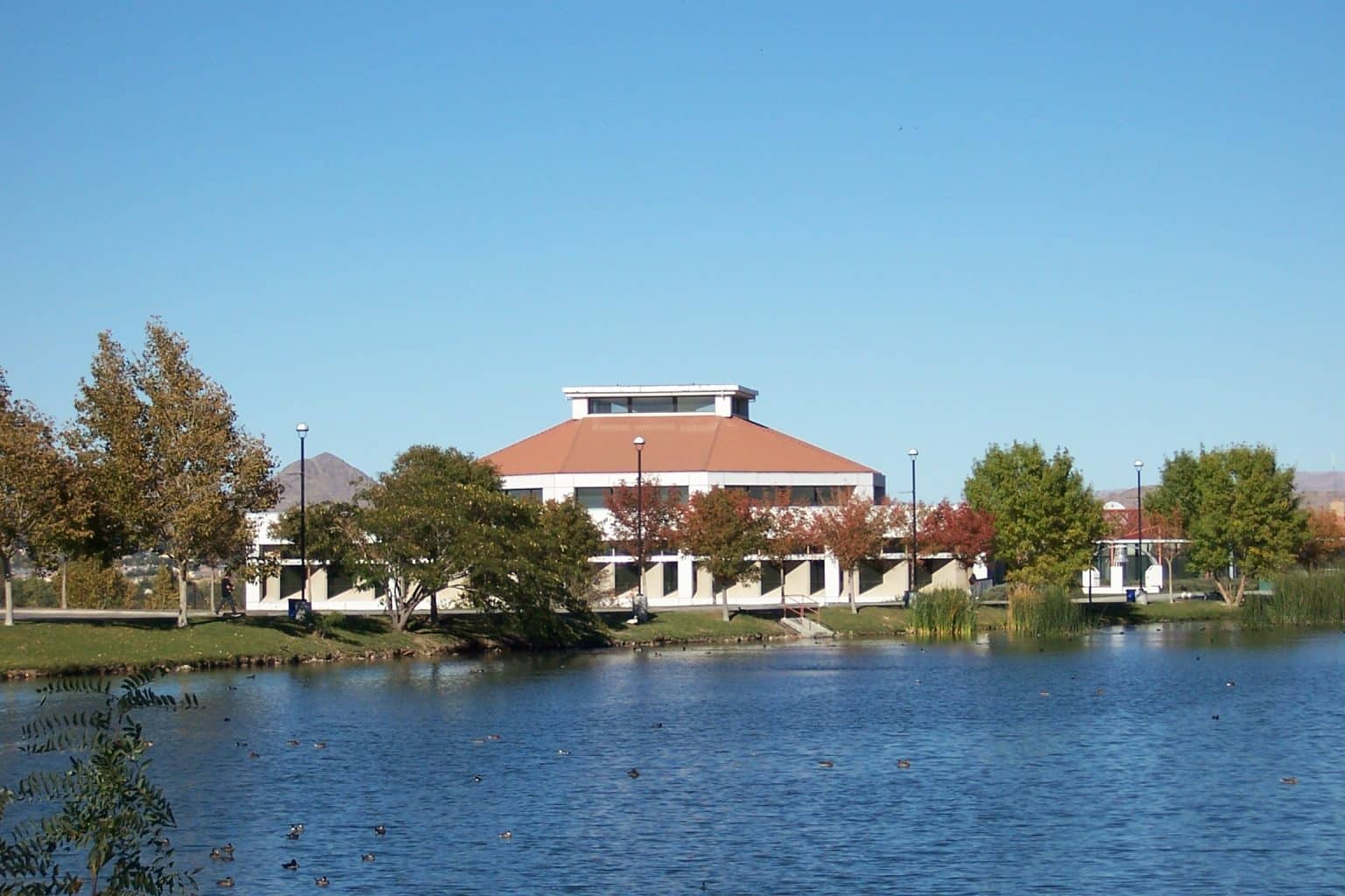 A Victor Valley College campus building across the campus lake on a clear autumn day
