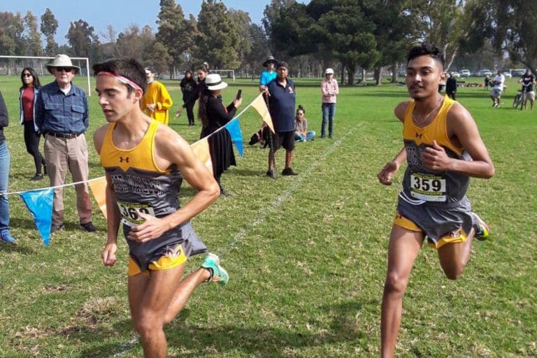 Two Victor Valley College Rams cross country runners racing at a championship meet